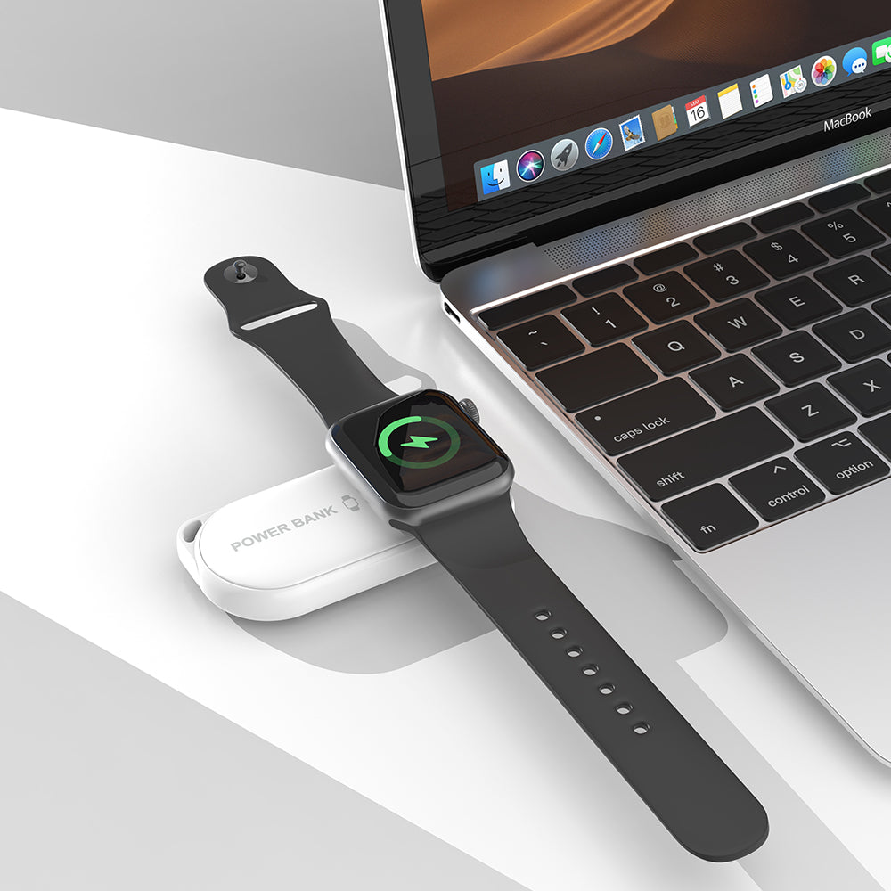 white iCharger MicroBOOST wireless Apple Watch charger next to MacBook for portable charging